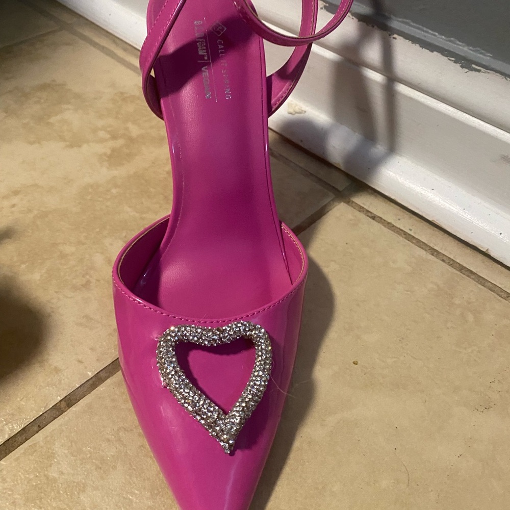 Pink vegan heels with a heart detail. Ankle strap closure.